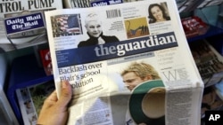 FILE - Britain's daily newspaper The Guardian is seen at a market in London.