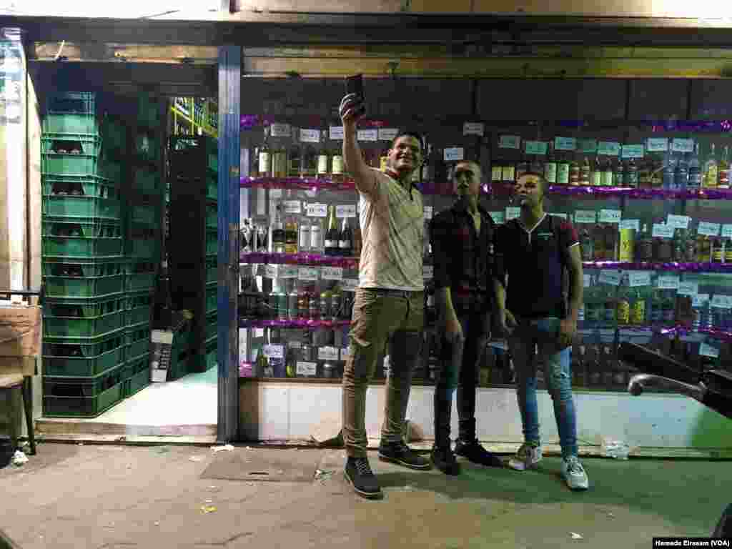 Young Egyptian men take a selfie photograph in front of one of the local liquor stores as they celebrate its reopening on the last day of Ramadan, in Cairo, Egypt, June 5, 2016. Liquor is legally prohibited for Egyptians in Egypt during the holy month of Ramadan.