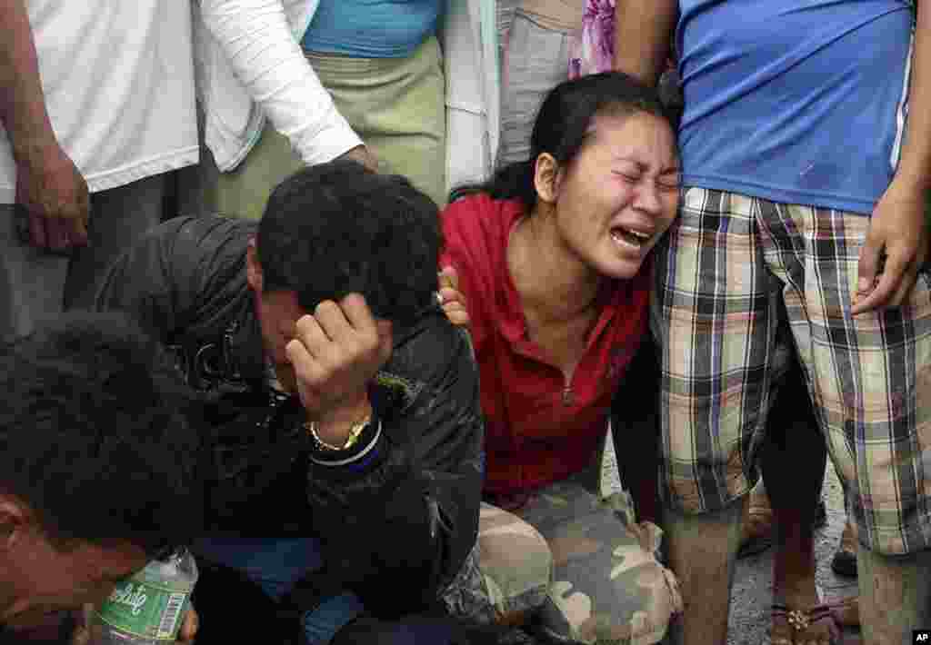 菲律宾孔波斯特拉省新巴丹镇发生水灾后遇难者的家属2012年12月5日在寻获的尸体前痛哭