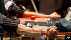 FILE - Donors give blood in Rutland, Vt