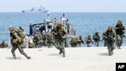 FILE - In this May 9, 2018 photo, Philippine and U.S. Marines storm a beach as part of an amphibious landing exercise during a two-week joint U.S.-Philippines exercise facing the South China Sea in the Philippines. 