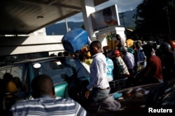 Motorbike riders and car drivers wait to get fuel at a gas station in Port-au-Prince, Haiti, April 4, 2019.