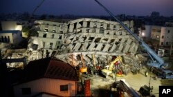 In the early morning, emergency rescuers continue to search for the missing in a collapsed building from an earthquake in Tainan, Taiwan, Feb. 7, 2016. 