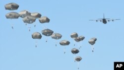 Airborne forces from the U.S., Great Britain and Poland conduct a multi-national jump on to a designated drop zone near Torun, Poland, June 7, 2016. The exercise, Swift Response-16, sets the stage in Poland for the multi-national land force training event