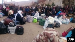 Syrians wait for the arrival of an aid convoy on Jan. 11, 2016 in the besieged town of Madaya as part of a landmark six-month deal reached in September for an end to hostilities in those areas in exchange for humanitarian assistance.