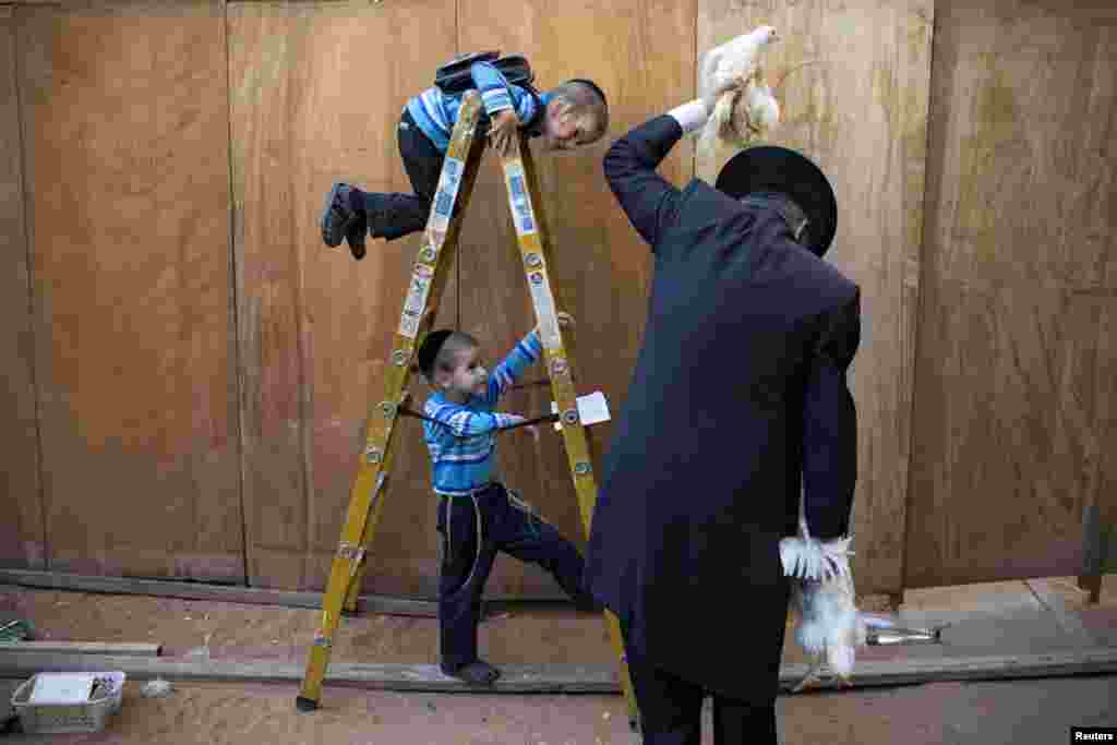 An ultra-Orthodox Jewish man swings a chicken over his head as part of the Kaparot ritual in the ultra-Orthodox city of Bnei Brak near Tel Aviv, Israel. Observers believe the ritual transfers one&#39;s sins from the past year into the chicken. The ritual is performed before the Day of Atonement, Yom Kippur, the holiest day in the Jewish year which starts at sundown Friday.