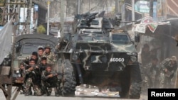 ທະຫານລັດຖະບານ ເຂົ້າຫາບ່ອນປ້ອງກັນ ໃນລະຫວ່າງ ການຍິງຕໍ່ສູ້ ກັບພວກກະບົດມຸສລິມ ຈາກກຸ່ມ Moro National Liberation Front (MNLF) ໃນເມືອງ Zamboanga, ພາກໃຕ້ຂອງ ຟີລິບປິນ. 12 ກັນຍາ, 2013.