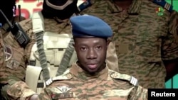 FILE - Captain Sidsore Kader Ouedraogo, spokesman for the Patriotic Movement for Safeguarding and Restoration, announces that the army has taken control of the country in Ouagadougou, Burkina Faso, Jan. 24, 2022.