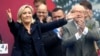 FILE - France's far right National Front political party leader Marine Le Pen (L) gestures at supporters.