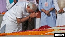 ທ່ານ Narendra Modi ສະແດງຄວາມເຄົາລົບ ທີ່ອະນຸສາວະລີ Mahatma Gandhi ທີ່ Rajghat ກ່ອນພິທີສາບານໂຕເຂົ້າ
ຮັບຕຳແໜ່ງ ຂອງທ່ານ ທີ່ກຸງ ນີວເດລີ ວັນທີ 26 ພຶດສະພາ 2014.
