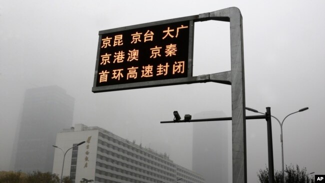2018年11月14日,中国首都被雾霾笼罩,屏幕显示几条高速公路关闭。当局当天发布了北京重度空气污染的黄色警报。(美联社)