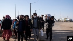 Deported Afghan migrants enter Afghanistan from Iran at the Islam Qala border crossing, Wednesday, Nov. 24, 2021. 