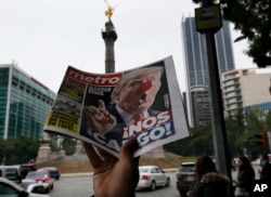 FILE - A street vendor hawks a newspaper emblazoned with an image of Donald Trump with a clown's nose and a headline that reads in Spanish: "We're screwed!" in Mexico City, Nov. 9, 2016.