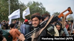 Des combattants talibans se rassemblent le long d'une rue lors d'un rassemblement à Kaboul le 31 août 2021 alors qu'ils célèbrent le départ des troupes américaines.