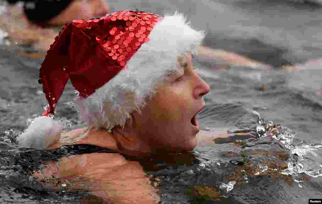 Seorang perenang bereaksi setelah menyelesaikan perlombaan tahunan yang diselenggarakan pada hari Natal di danau Serpentine di Hyde Park, London, Inggris.