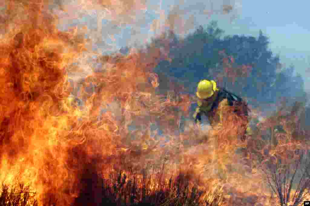 A firefighter battles the wildfire in Cabazon, Califoria, August 8, 2013.