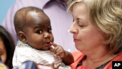 Ibu angkat, Nancy Swabb (kanan) menggendong bayi Dominique (10 bulan) di rumah sakit Park Ridge, Illinois, AS (21/3). 