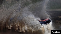 Sébastien Loeb de la France roule sur une flaque d’eau avec sa Peugeot pendant le prologue Buenos Aires-Rosario du Rallye Dakar 2016 à Arrecifes, Argentine, 2 janvier, 2016.