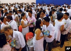 Filipino couples kiss during a mass wedding ahead of Sunday's Valentine's Day celebration in Manila, Philippines, Feb. 12, 2016 (AP Photo/Bullit Marquez)