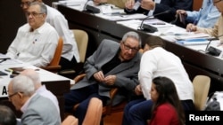古巴前總統卡斯特羅(中)12月21日在議會與其保鏢兼孫兒講話。