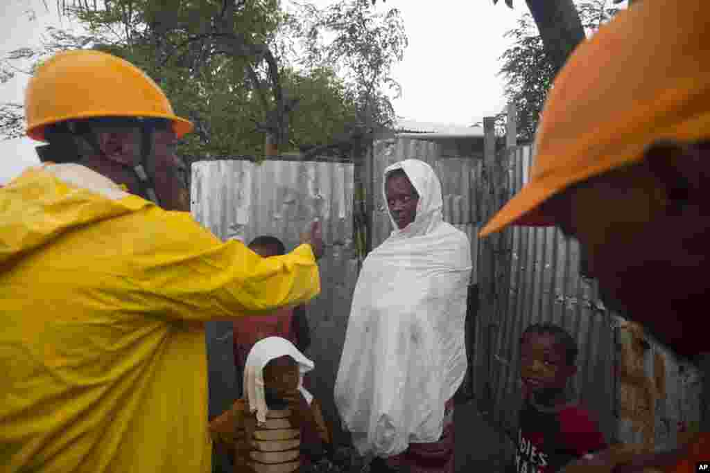 Civil protection workers asks residents to evacuate their homes located near the the Grise river, in Tabarre, Haiti, Oct. 3, 2016.