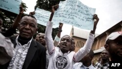 Des Congolais brandissent des pancartes lors d'une manifestation à Kinshasa, le 12 janvier 2018.