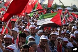 People holding Turkish and Palestinian flags attend a rally in solidarity with Palestinians before an extraordinary summit of the 57-member Organization of Islamic Cooperation (OIC), in Istanbul, May 18, 2018.