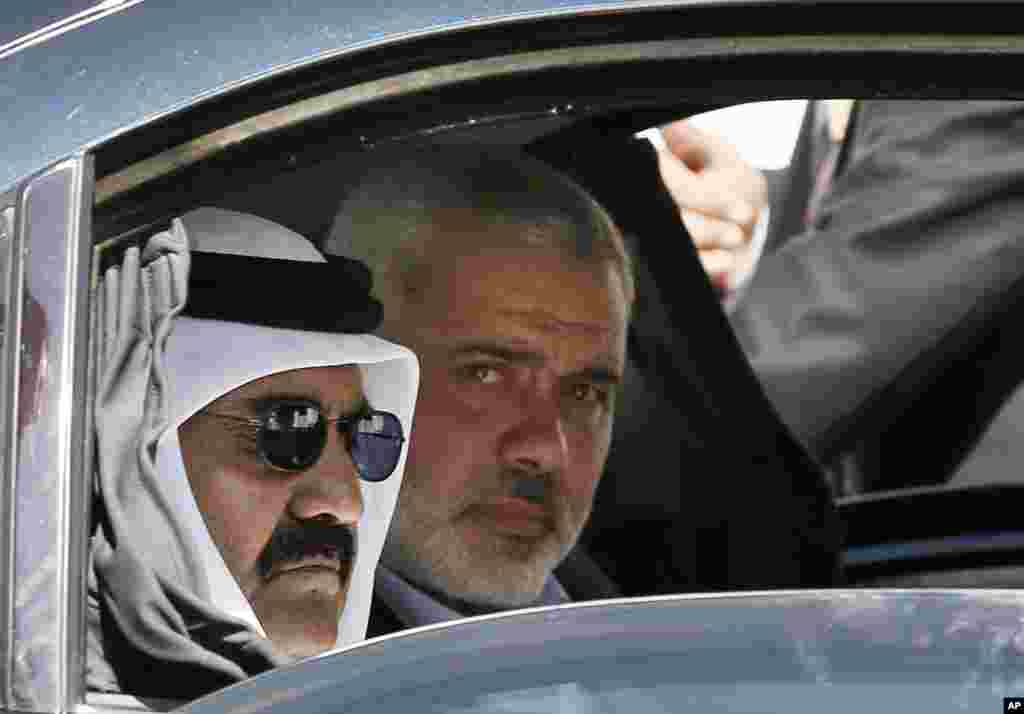 Quốc vương Qatar Hamad bin Khalifa al-Thani (tr&aacute;i) c&ugrave;ng thủ tướng Ismail Haniyeh của ch&iacute;nh quyền Hamas quản l&yacute; Dải Gaza (phải) tr&ecirc;n đường đến dự buổi lễ khởi c&ocirc;ng x&acirc;y dựng một khu d&acirc;n cư mới ở Khan Younis, ph&iacute;a nam Dải Gaza, ng&agrave;y 23 th&aacute;ng 10, 2012. 