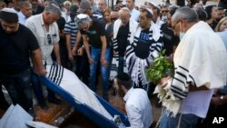 In this May 18, 2021 file photo, mourners attend the funeral of Yigal Yehoshua, 56, at a cemetery in Hadid, central Israel. (AP Photo/Oded Balilty, File)