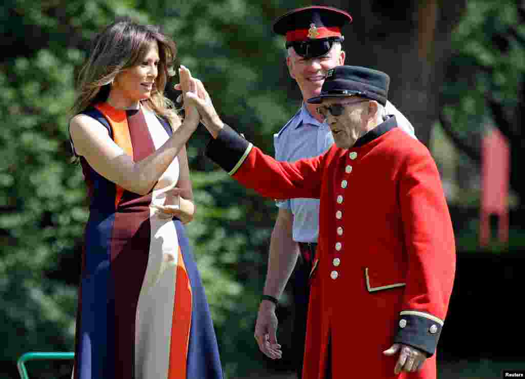 U.S. First Lady Melania Trump high-fives with a British military veteran known as a &quot;Chelsea Pensioner&quot; during a game of bowls at The Royal Hospital Chelsea in central London, England.