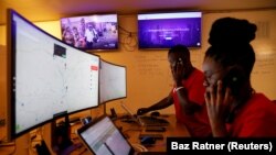 Des répartiteurs du service d'ambulances gratuites Rescue.co devant des écrans d'ordinateur à Nairobi, au Kenya, le 11 juin 2020.