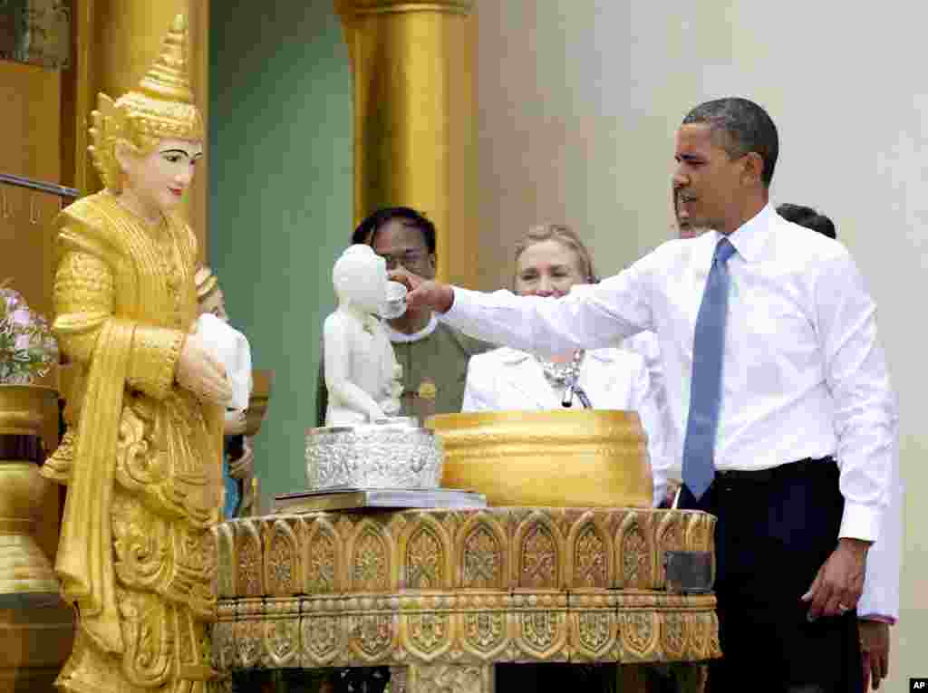 ປະທານາທິບໍດີ ສະຫະລັດ ທ່ານ Barack Obama &quot;ສົງພະສິບເອັດແສງ&quot; ໃນຂະນທີ່ທ່ານ ເດີນທ່ຽວຊົມວັດ Shwedagon ກັບທ່ານນາງ Hillary Rodham Clinton ທີ່​ນະຄອນ​ຢ່າງ​ກຸ້ງ ໃນວັນທີ 19 ພະຈິກ 2012. (AP Photo/Carolyn Kaster) 