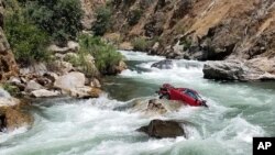 This Aug. 5, 2017, photo provided by the Fresno County Sheriff’s office shows a car in the middle of Kings River near Fresno, Calif. 