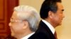 FILE - China's Foreign Minister Wang Yi (R) walks past Vietnam's Communist Party's General Secretary Nguyen Phu Trong.