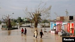 열대성 폭풍 파일린이 강타한 인도 동부 오디사주에서 주민들이 물에 잠긴 거리를 건너고 있다.
