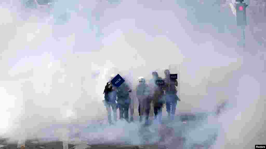 Riot police walk through a cloud of tear gas as they clash with May Day protesters in central Istanbul May 1, 2013.