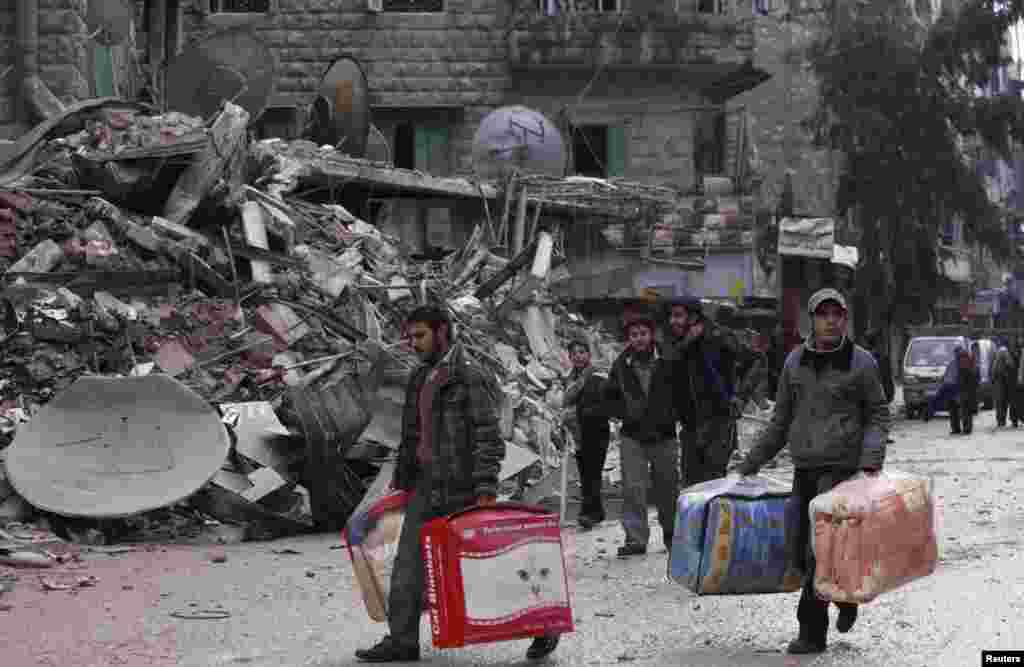Residents evacuate their houses after being targeted by missiles fired by forces loyal to Syria's President Bashar al-Assad, in Aleppo's al-Mashhad district, Syria, January 9, 2013. 