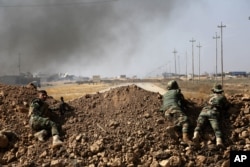 Kurdish security forces take up a position as they fight overlooking the Islamic State-controlled in villages surrounding Mosul, in Khazer, about 30 kilometers (19 miles) east of Mosul, Iraq, Oct. 17, 2016.