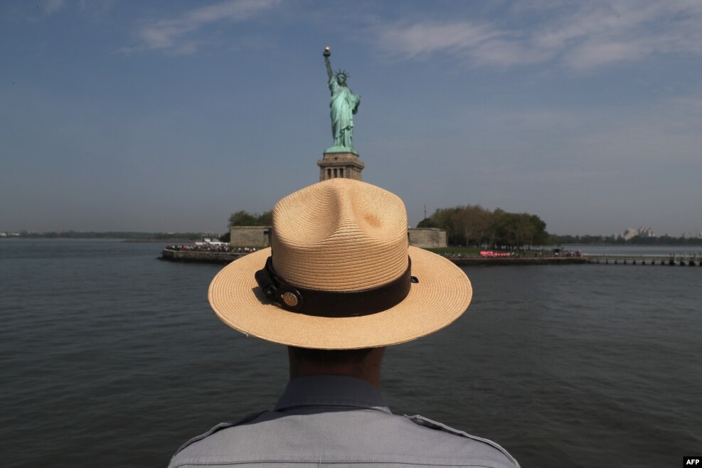 A U.S. park ranger looks towards the Statue of Liberty while in route to Ellis Island in New York City. U.S. Secretary of Homeland Security Jeh Johnson visited the historic island to administer the oath of citizenship to immigrants from 39 countries.
