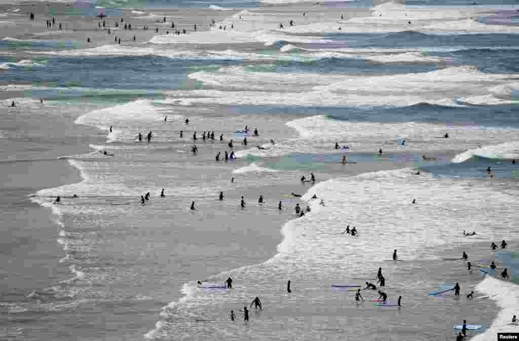 Surfers are seen in the sea ahead of the G7 Summit in the French coastal resort of Biarritz, France.