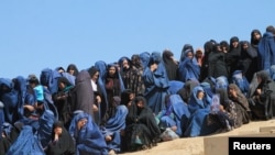 Female Villagers attend the burial ceremony of civilians who were killed by insurgents at Mirza Olang village, in Sar-e Pul province, Afghanistan.