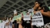 FILE - A migrant workers alliance group holds placards to protest the killings of two Indonesian women in 2014, outside the High Court in Hong Kong, Oct. 24, 2016. 