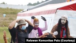 Anak-anak mengikuti gerak pemain pantomim di Stadion Manakara, Kabupaten Mamuju. Senin (25/1/2021). (Foto: Courtesy/Relawan Komunitas Palu)