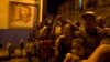 People watch a march in celebration of the 162nd birth anniversary of Cuba's independence hero Jose Marti beside an image of Cuban revolutionary hero Ernesto 'Che' Guevara on a wall in downtown Havana, Jan. 27, 2015. Thousands of members from the Cuban Communist Youth Union (UJC) and student organizations participated in the march.