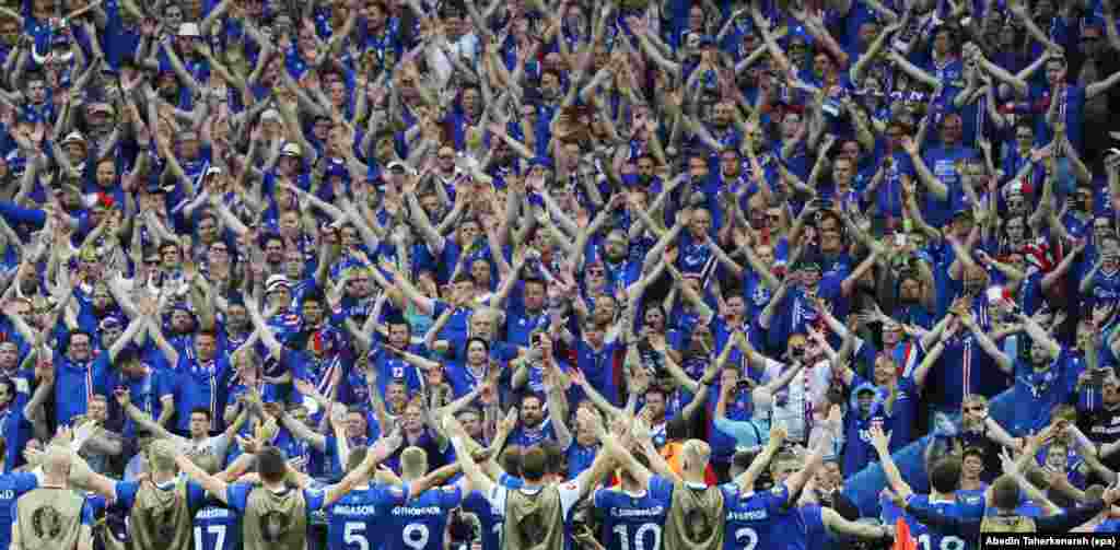 Players for the Iceland national soccer team celebrate with their fans after the final whistle of the UEFA EURO 2016 group F preliminary round match between Iceland and Austria at Stade de France in Saint-Denis, France, June 22, 2016. Iceland won 2-1.