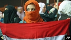 A woman holds a Syrian flag as Jordanians and Syrians protest against Syrian President Bashar Al-Assad in Amman, Jordan, October 3, 2011.