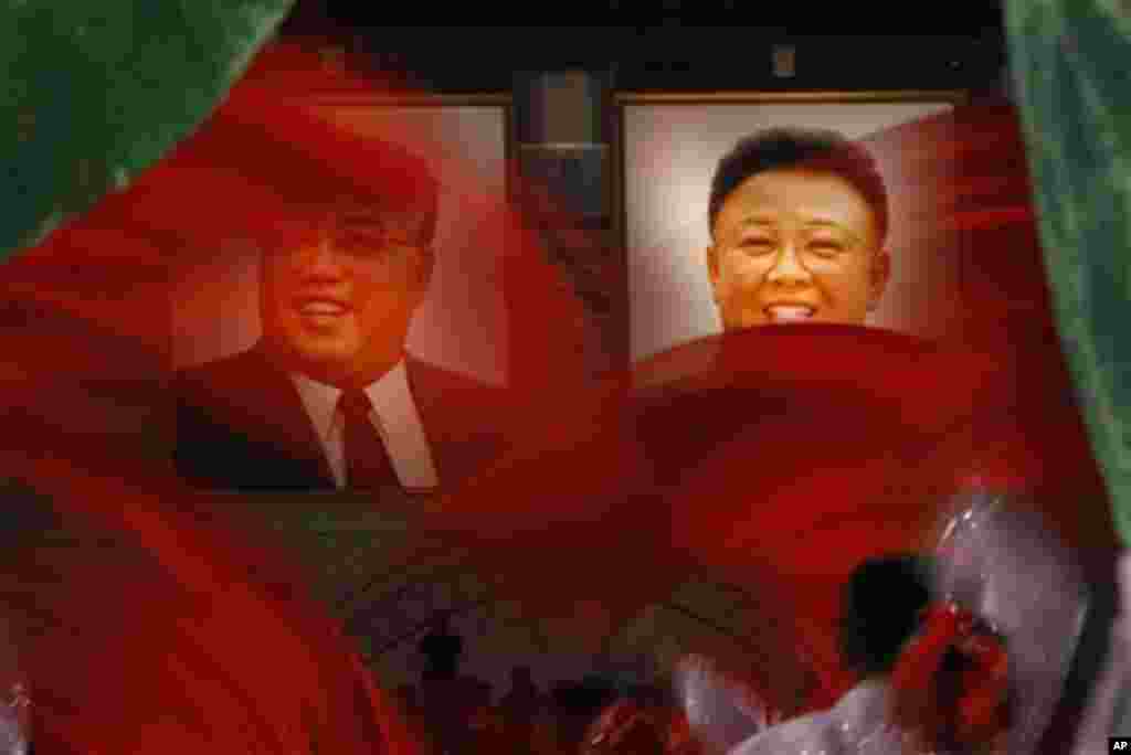 North Korean dancers perform in front of portraits of the late leaders, Kim Il Sung, left, and his son Kim Jong Il, at Kim Il Sung Square in Pyongyang, North Korea, to celebrate 100 years since the birth of the North Korean founder Kim Il Sung, Monday, Ap