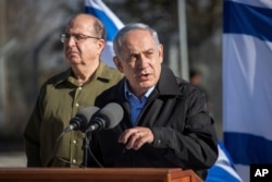 ນາຍົກລັດຖະມົນຕີ Israel ທ່ານ Benjamin Netanyahu ຢືນຟຽງຂ້າງກັບລັດຖະມົນຕີປ້ອງກັນປະເທດ ທ່ານ Moshe Yaalon (ຊ້າຍ) ໃນຂະນະທີ່ຢ້ຽມຢາມຄ້າຍທະຫານ ໃກ້ໆກັບເຂດ Gush Etzion ທີ່ຕັ້ງຮາກຖານຂອງຊາວຢິວ ໃນ West Bank, 23 ພະຈິກ, 2015.