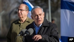 Israel's Prime Minister Benjamin Netanyahu stands with Defense Minister Moshe Yaalon (L) during a visit to an army base near the Gush Etzion bloc of Jewish settlements in the West Bank, Nov. 23, 2015.