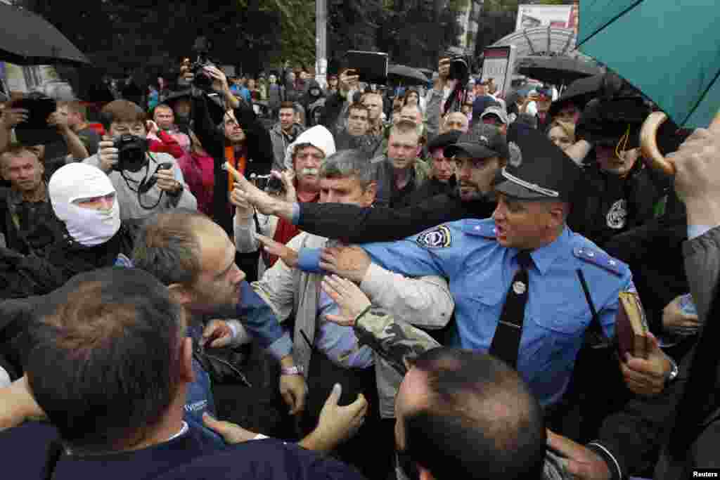 A police officer tries to prevent activists and relatives of Ukrainian soldiers from getting into the defense ministry building during a protest, in Kyiv, Aug. 28, 2014.&nbsp;